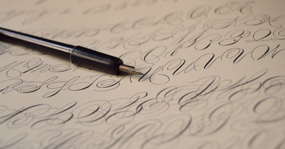 Close-up of elegant calligraphy handwriting using a fountain pen on paper, showcasing artistic lettering.